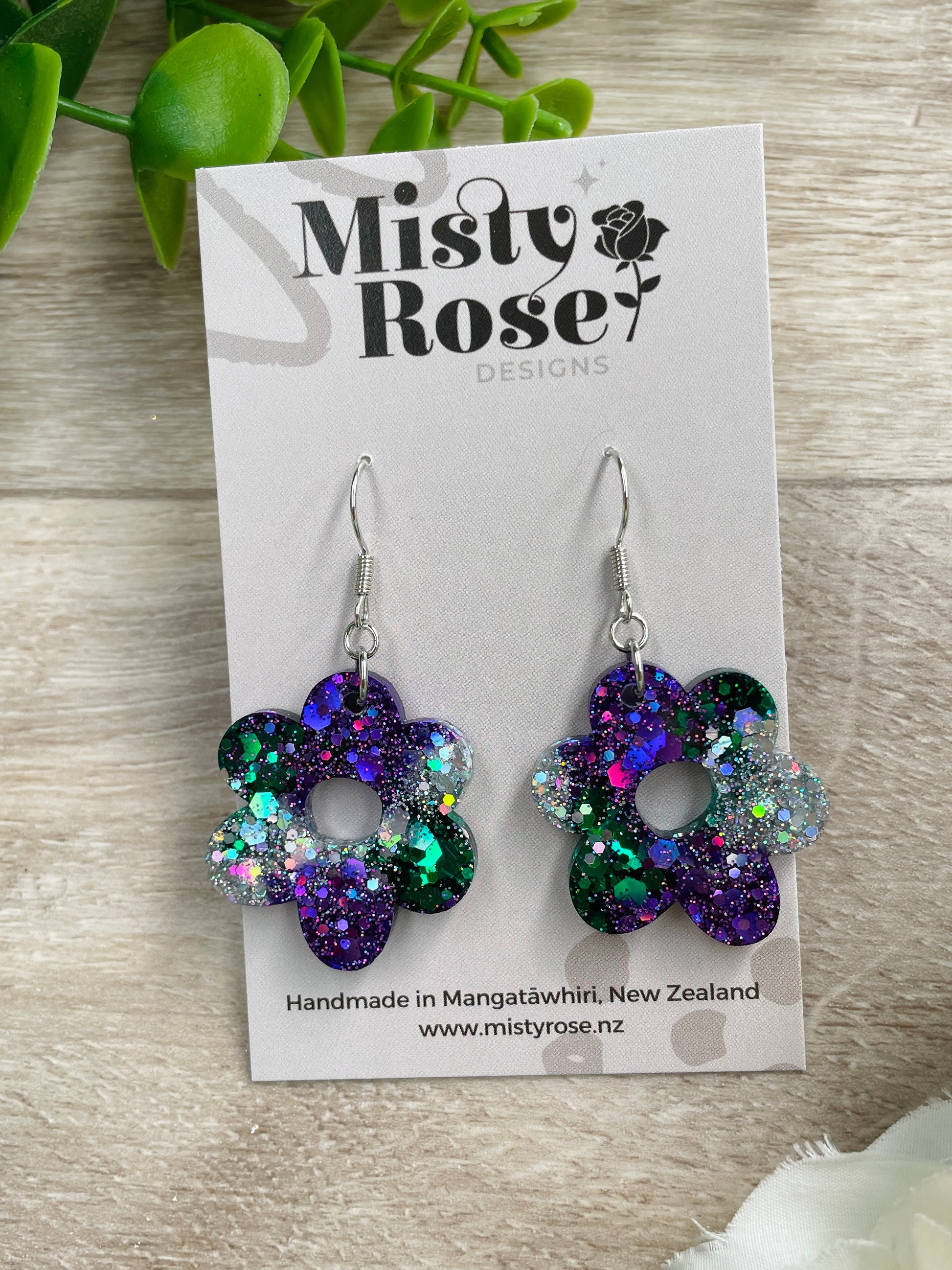 Absolutely stunning medium sized flower earrings!&nbsp;Lovely organic shape 🌸  Mix of emerald green, dark violet purple and silver holographic glitter 💜💚  Approx 2.7cm x 3cm&nbsp;  Lovely &amp; lightweight, these earrings are sure to add some sparkle to any outfit!&nbsp;   Handmade in Waikato, New Zealand - Each pair is a one of a kind find, you will not see anyone else wearing these cuties!&nbsp;