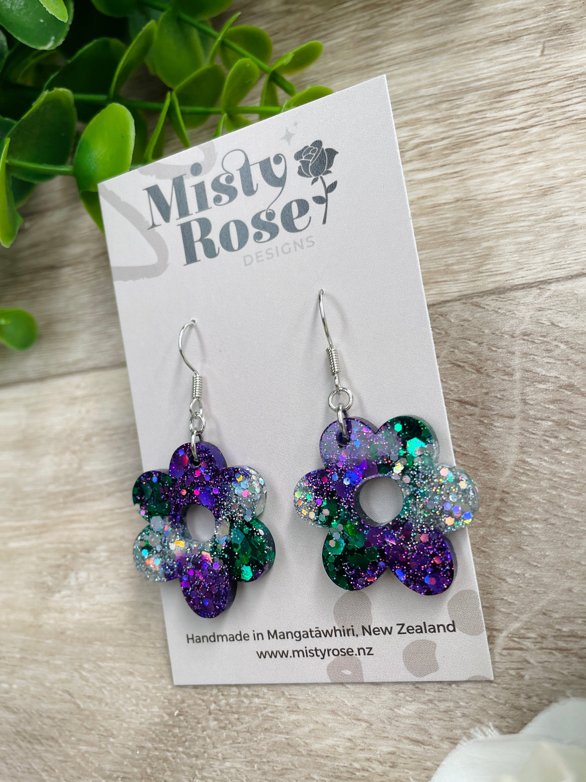 Absolutely stunning medium sized flower earrings!&nbsp;Lovely organic shape 🌸  Mix of emerald green, dark violet purple and silver holographic glitter 💜💚  Approx 2.7cm x 3cm&nbsp;  Lovely &amp; lightweight, these earrings are sure to add some sparkle to any outfit!&nbsp;   Handmade in Waikato, New Zealand - Each pair is a one of a kind find, you will not see anyone else wearing these cuties!&nbsp;