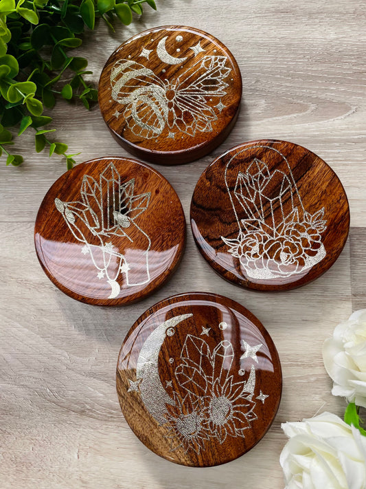 Gorgeous set of four magical coasters.  Textured light gold image sealed with a top coat of resin ✨✨  Great as a housewarming gift or a treat for yourself!  Images are:  • Crystal lunar butterfly • Crystal bell jar with florals • Goddess hand with crystals • Moon with crystals Set of x4 Approx 100mm diameter