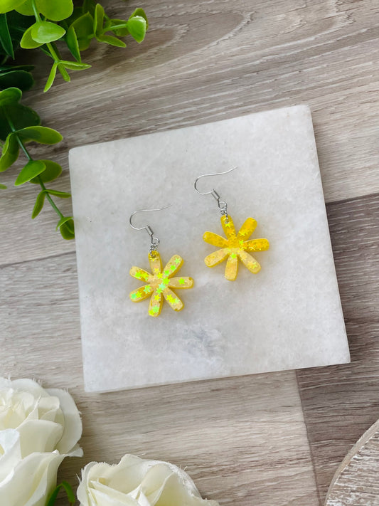Photograph of one pair of epoxy resin earrings on timber background. The colours of the earrings are sunshine yellow. Handmade earrings by Misty Rose Designs, New Zealand.